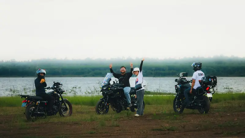 Friends with their motorcycles beside a lake