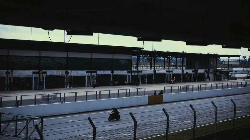 A rider on a race track below the grandstands